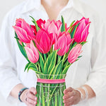 woman holding pink tulip bouquet