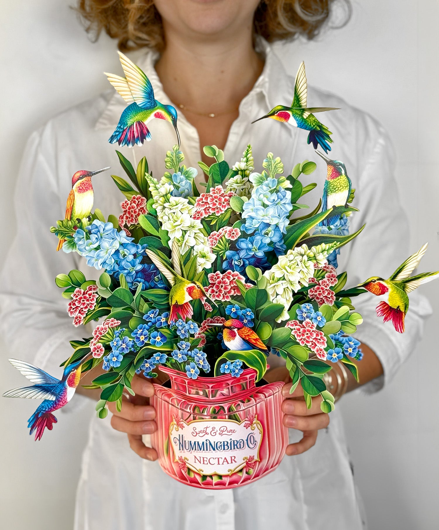 a woman holding a vase of flowers